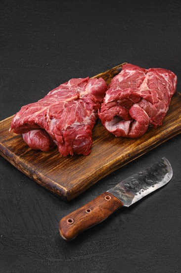 Raw rolled lamb boneless neck meat on cutting board