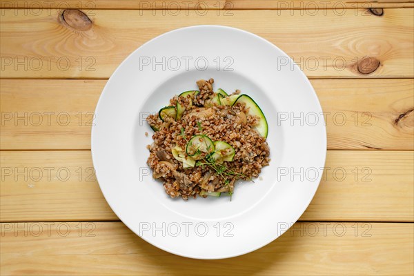 Overhead view of boiled buckwheat with marinated mushrooms and fresh cucumber