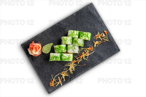 Set of rolls with wasabi and pickled ginger on stone serving board isolated on white