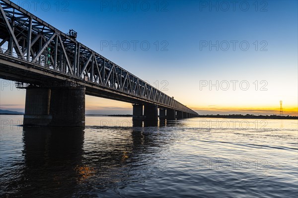 Giant bridge spanning over the Amur river at sunset