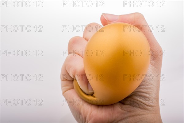 Squeezing yellow balloon with hand on a white background