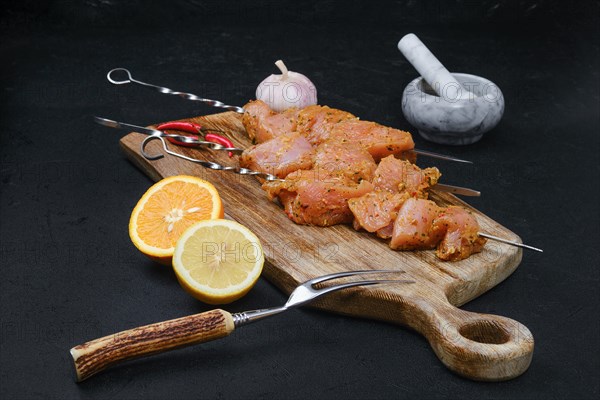 Skewers with raw turkey meat with sweet and spicy rub on dark background