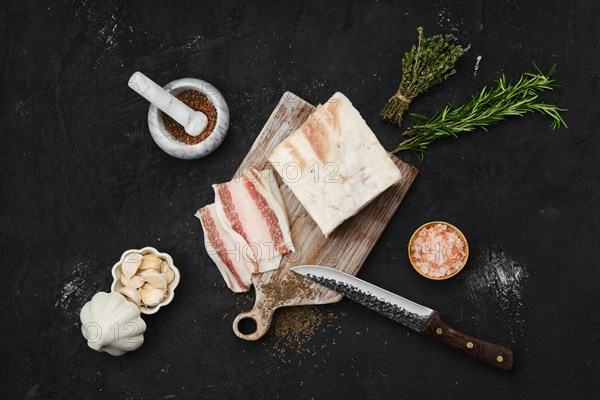 Overhead view of salted pork belly lard on cutting board