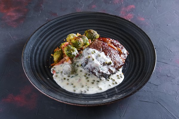 Fried beefsteak with Brussels sprouts and creamy pea sauce