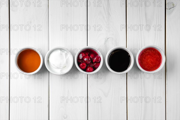 Assortment of different sauce on white wooden table