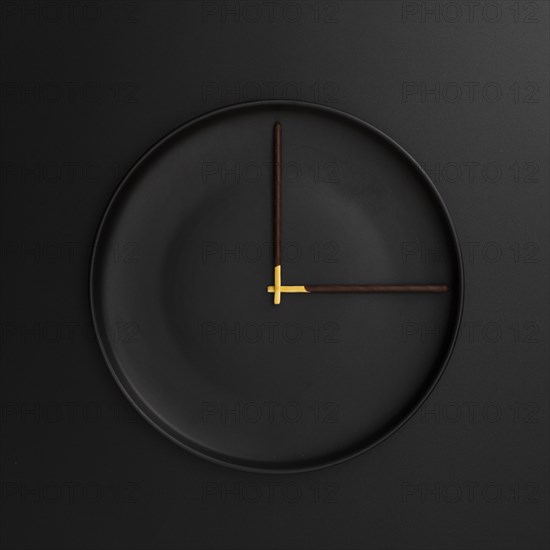Dark plate with chocolate sticks form clock
