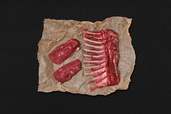 Overhead view of raw fresh rack of lamb and steak in wrapping paper