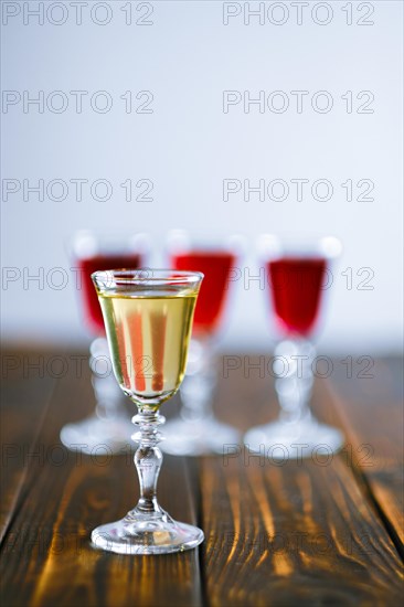 Vodka infused with berries on wooden background