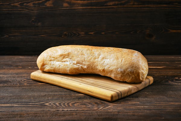 Freshly baked ciabatta on brown wooden table