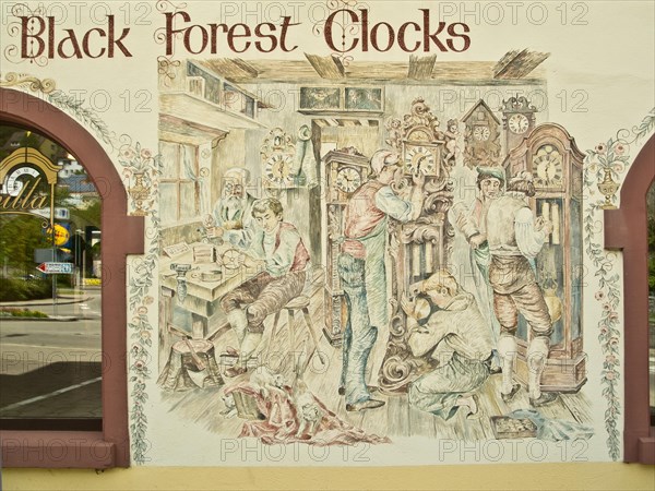 Clockmaker depicted in a facade painting of a Black Forest clock shop in Triberg