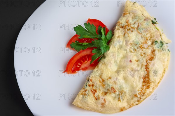 Closeup of omelet with ham and vegetables