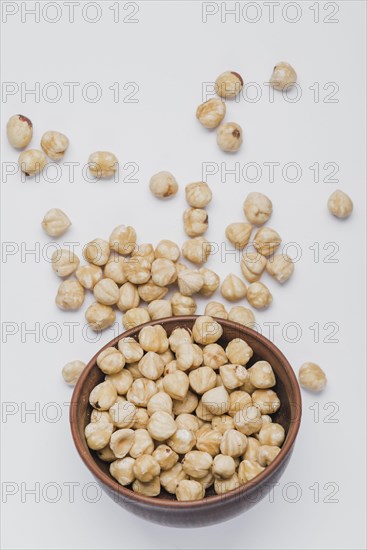 Hazelnuts spilled near bowl
