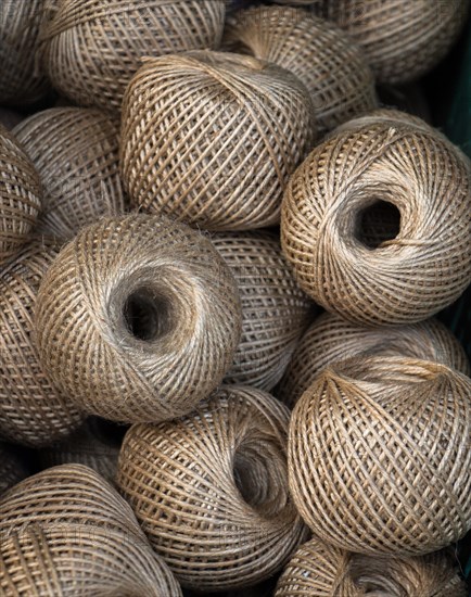 Plenty of spools or rolls of brown color linen string