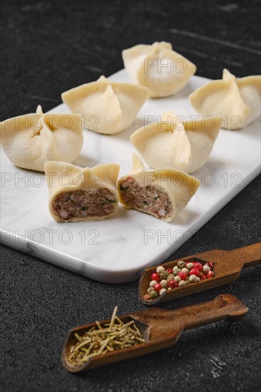 Homemade spicy beef dumplings on marble serving plate