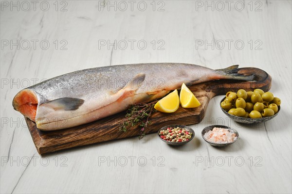 Headless fresh yellow tailed lacedra on wooden cutting board