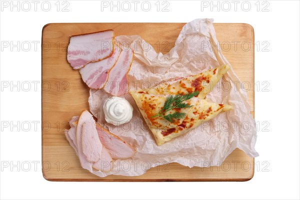 Thin pancakes stuffed with ham and bacon isolated on white