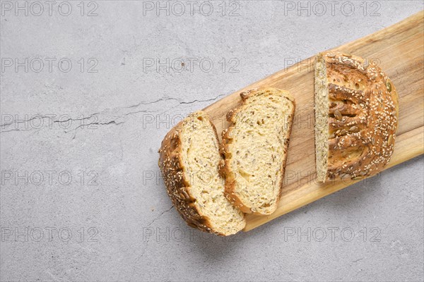 Fresh oats bread with sunflower seeds and sesame on wooden table