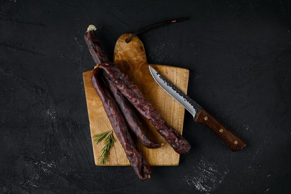 Top view of dry cured beef sausage on cutting board