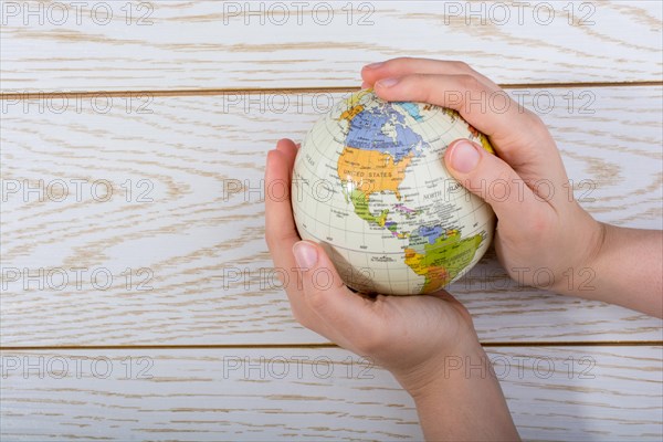 Hand holding a globe with map on it