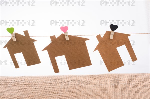 Little paper houses attached to a string with a heart clip