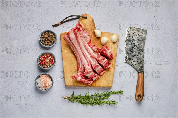 Overhead view of raw fresh deer ribs with spice and herb over concrete background