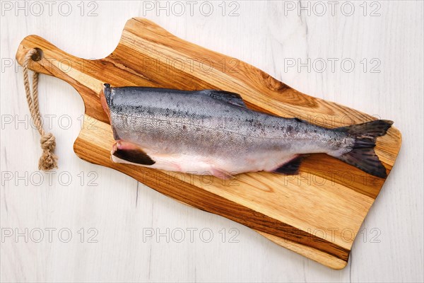 Top view of raw fresh headless pink salmon on wooden cutting board