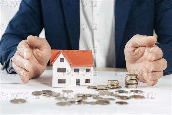 Close up hands with coins house