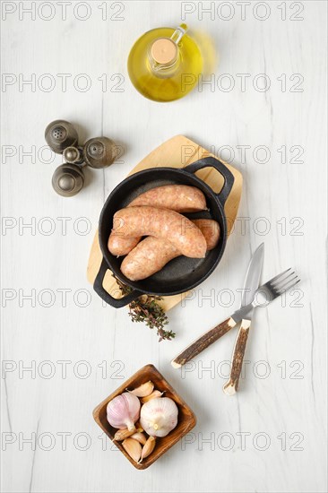 Raw traditional homemade British banger pork sausage ready for frying on wooden table