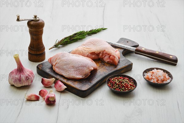 Raw chicken thighs on wooden cutting board ready for cooking