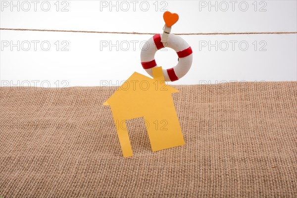 Model house and a life preserver with a heart on a string