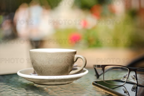 Cup of cappuccino on caffe terrace table with blurred background