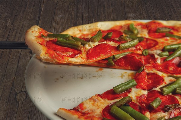 Slice of pizza pepperoni on scapula. Levitatating piece of pizza