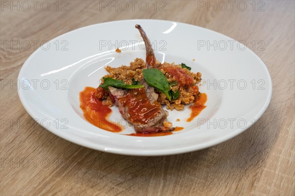 Fried lamb rib with quinoa porridge on wooden table