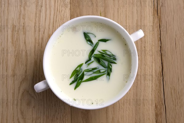 Top view of soup puree with onion on wooden table