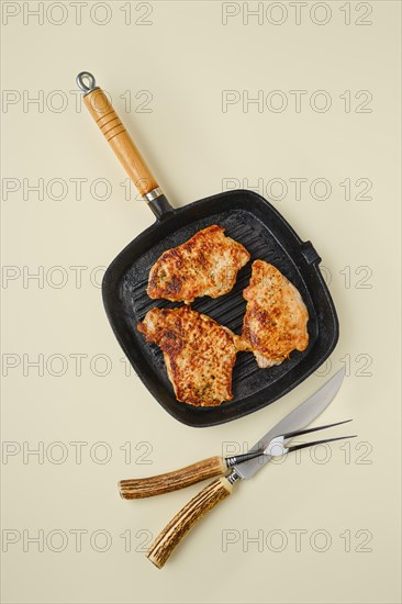 Overhead view of fried chopped pork tenderloin on frying pan