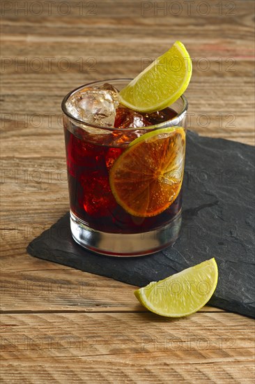 Rum and cola cocktail on wooden background