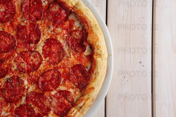 Classic pizza pepperoni on wooden background