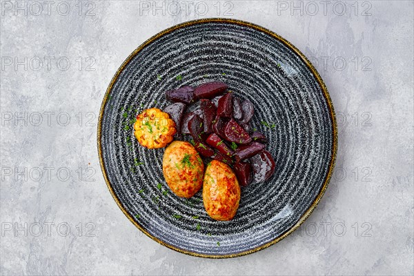 Top view of plate with fried pork cutlet with roasted beetroot slices and grilled maize