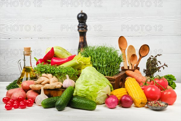 Variety of fresh juicy vegetables on white wooden background. World vegan day concept