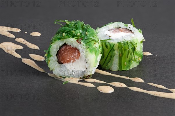 Rolls with tuna in green seawed with nut sauce