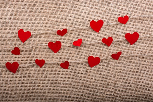 Love concept with heart shaped papers on linen threads