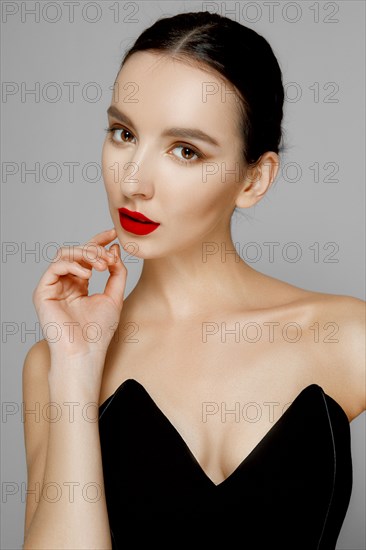 Pretty young fashion model with tan skin and red mat lips. Beauty shoot