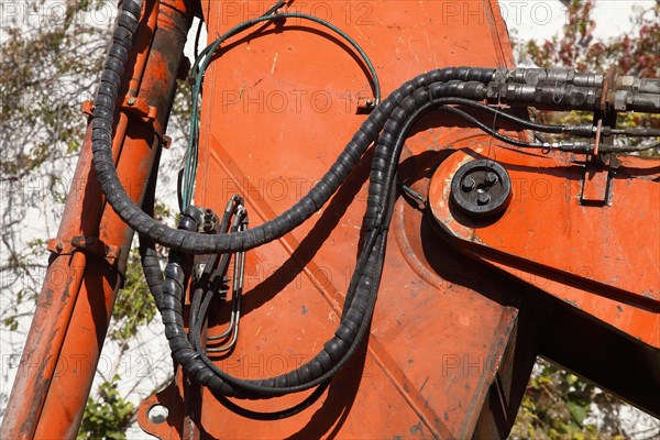 Orange hydraulic excavator arm of an excavator on a construction site