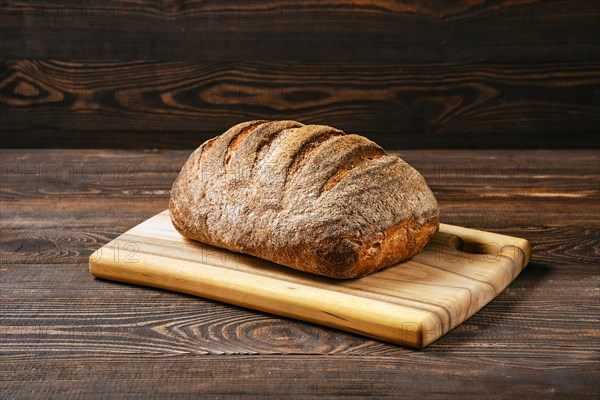 Loaf of artisan sourdough bread with porous texture on wooden table