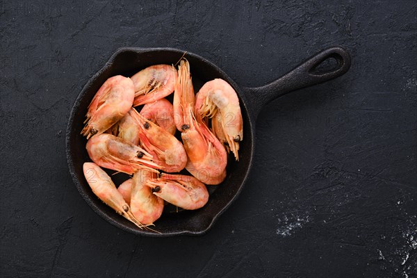 Top view of cast iron skillet with steamed unpeeled shrimps