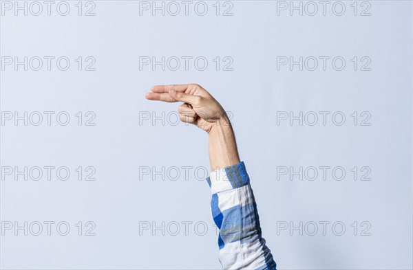 Hand gesturing the letter H in sign language on an isolated background. Man's hand gesturing the letter H of the alphabet isolated. Letters of the alphabet in sign language