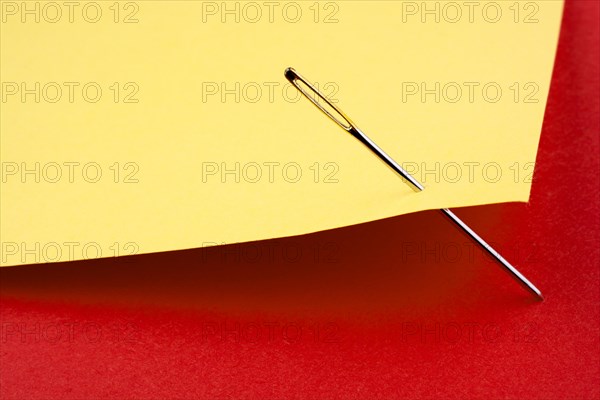 Needle pierced yellow color note paper on red one