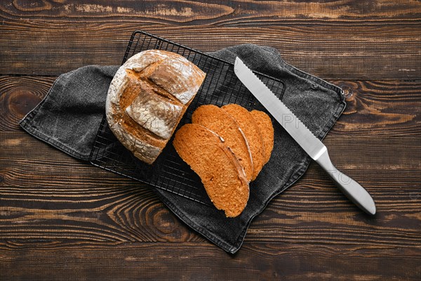 Overhead view of artisan whole grain tomato wheat bread cut on slices on wooden table