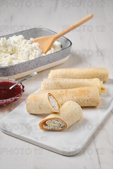 Homemade pancakes stuffed with cottage cheese on marble serving plate