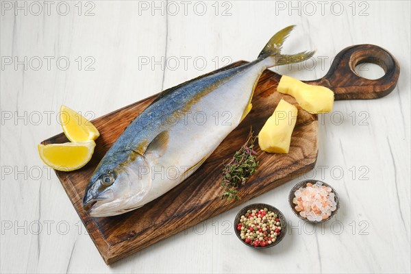 Whole fresh chinook on wooden cutting board with spice